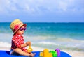 Cute little girl with sand toys on the beach