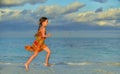 Cute little girl on sandy beach in sunset light. Royalty Free Stock Photo