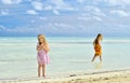 Cute little girls on sandy beach in sunset light Royalty Free Stock Photo