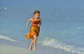 Cute little girl on sandy beach in sunset light. Royalty Free Stock Photo