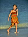 Cute little girl on sandy beach in sunset light. Royalty Free Stock Photo