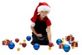 Cute little girl in a Santa Claus cap with Christmas baubles, is Royalty Free Stock Photo