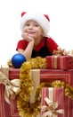 Cute little girl in a Santa Claus cap with Christmas gifts, isol