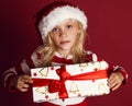 Cute little girl in santa hat holding christmas present Royalty Free Stock Photo