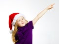 Cute little girl in santa red hat showing by hand Royalty Free Stock Photo