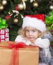 Cute little girl in Santa's hat with big Christmas gift Royalty Free Stock Photo