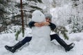 Cute little girl sculpts snowman in winter snowy Park Royalty Free Stock Photo
