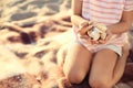 Cute little girl with sea shells on beach Royalty Free Stock Photo