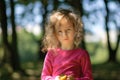 A Cute little girl , serious look, curly hair, sunny summer portrait Royalty Free Stock Photo