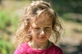 Cute little girl , serious look, curly hair, sunny summer portrait Royalty Free Stock Photo