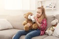 Cute little girl sharing her tea with her friend teddy bear Royalty Free Stock Photo