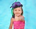 Summer rocks. A cute little girl showing a thumbs up while in her swimsuit at the pool. Royalty Free Stock Photo