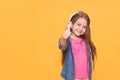 Cute little girl showing thumbs up one yellow background Royalty Free Stock Photo