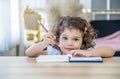 Cute little girl sit at desk at home doing homework, reading, writing and painting. Children paint. Kids draw. Royalty Free Stock Photo