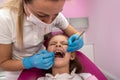 cute little girl sits on a dental chair and treats aching teeth, makes a face. Royalty Free Stock Photo