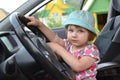 Cute little girl is sitting behind the wheel of a car Royalty Free Stock Photo