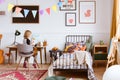Cute little girl sitting at desk in her stylish vintage bedroom with workspace