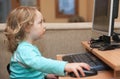 Little girl playing with computer keyboard and mouse Royalty Free Stock Photo
