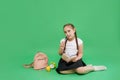 Cute little girl is sitting on the floor, holding notebook on her knee, pen near her mouth, thinking about what to write. A lot of Royalty Free Stock Photo