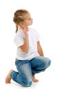 A little girl is sitting on the floor in a clean white T-shirt. Royalty Free Stock Photo