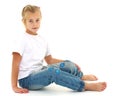 A little girl is sitting on the floor in a clean white T-shirt. Royalty Free Stock Photo