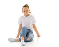 A little girl is sitting on the floor in a clean white T-shirt. Royalty Free Stock Photo