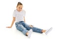 A little girl is sitting on the floor in a clean white T-shirt. Royalty Free Stock Photo