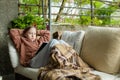 Cute little girl sitting in a garden under a blanket and reading a book on sunny summer evening Royalty Free Stock Photo