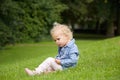 Cute little girl sitting on green grass outdoors Royalty Free Stock Photo