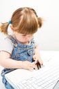 Cute little girl sitting with a laptop Royalty Free Stock Photo