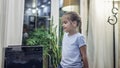 Cute little girl sitting near portable air purifier in the living room at home, new technology to protect