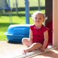 Cute little girl sitting at opened sliding door Royalty Free Stock Photo