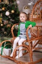 Cute little girl sitting in rocking chair near christmas tree Royalty Free Stock Photo