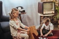 cute little girl sitting on rocking horse and brother playing with domino tiles behind at home Royalty Free Stock Photo