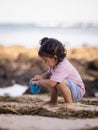 Cute little girl sitting on sandy beach, playing with bucket and sand. Happy childhood. Summer vacation. Holiday concept. Baby Royalty Free Stock Photo