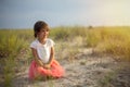 Cute little girl sitting on sandy hill on summer beach Royalty Free Stock Photo