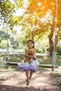 Cute little girl sitting swings , teddy bear sitting with her,little girl pointed to the tree Royalty Free Stock Photo