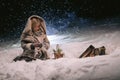 Cute little girl warming herself by the fire in the winter evening Royalty Free Stock Photo