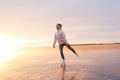 Cute little girl is skating on a frozen lake. Silhouette. Happy childr playing on a winter walk in nature Royalty Free Stock Photo