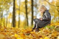 Cute little girl sketching outside on beautiful autumn day. Happy child playing in autumn park. Kid drawing with colourful pencils Royalty Free Stock Photo