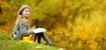 Cute little girl sketching outside on beautiful autumn day. Happy child playing in autumn park. Kid drawing with colourful pencils Royalty Free Stock Photo