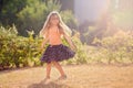 Cute little girl with skirt, dancing and swirling around, summer