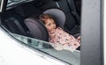 Cute little girl sleeping inside of the car. Conception of traveling and vaccation