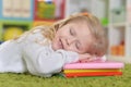 Cute little girl sleeping on pile of books Royalty Free Stock Photo