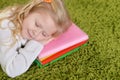 Portrait of cute little girl sleeping on pile of books Royalty Free Stock Photo