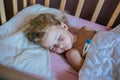 Cute little girl sleeping on a pillow in her bed with the thermometer.Measure the temperature. Girl is sick, the child has a cold Royalty Free Stock Photo