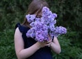 Cute little girl smelling lilac Royalty Free Stock Photo