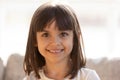 Cute little girl smiling looking at camera indoors, headshot portrait Royalty Free Stock Photo