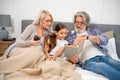 Cute little girl smiling when reading book with grandparents Royalty Free Stock Photo