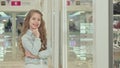 Cute little girl smiling to the camera, examining fashion store display Royalty Free Stock Photo